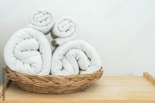 neat rolls of white cotton towel on basket in bedroom for bath © jummie