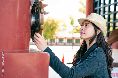 woman touching wooden sculpture in temple photo