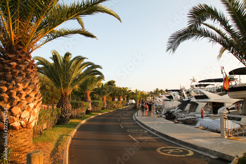 View of people walking along the marina at Cala Llonga, Cala d'Or, Mallorca