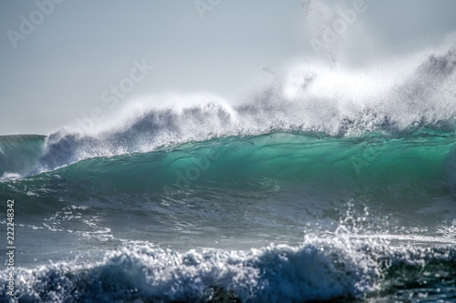 Turquoise blue wave breaking white