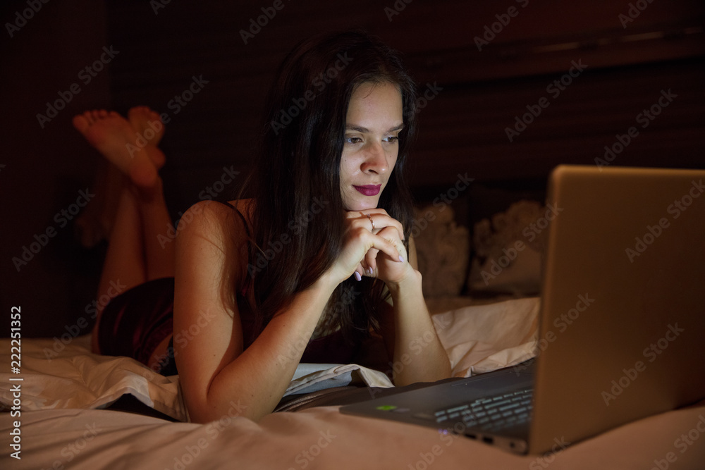 © Aleksei Lazukov - work with a laptop lying on your bed in the evening