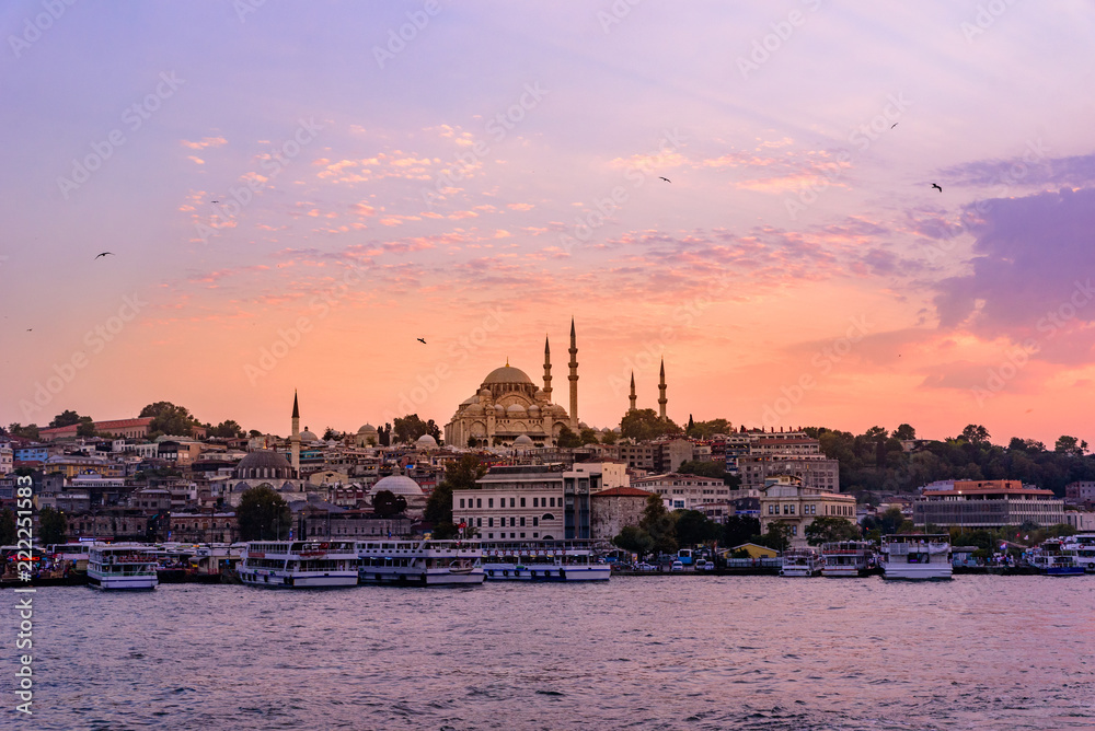 Eminonu Port with Ships and Suleymaniye Mosque in the Fatih district at Golden Horn River before sunset, Istanbul, Turkey. Travel concept and Sea front landscape of Istanbul historical part.