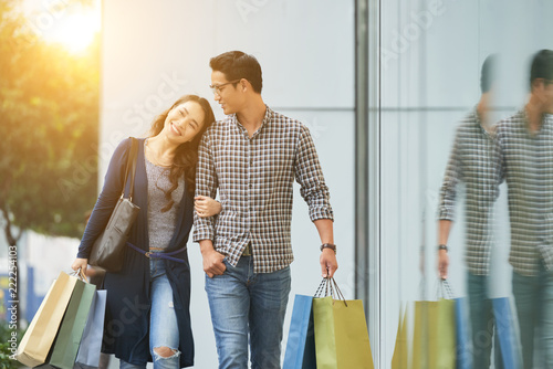 Happy young Asian couple in love enjoyng shopping together photo