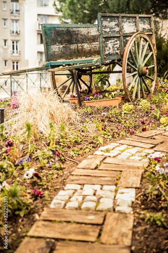 Wooden wagon in a park, surrounded by flowers photo