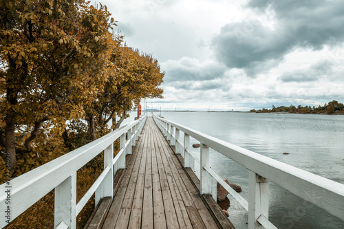 Wooden bridge along the shore of the Baltic Sea, in the capital of Finland, Helsinki, autumn landscape
