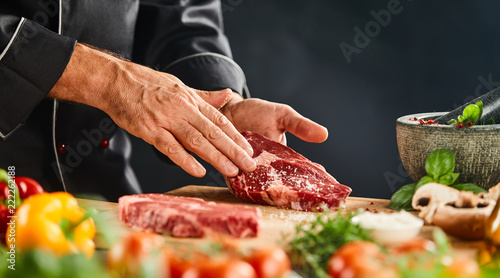 Unidentified man holding raw beef in his hands photo