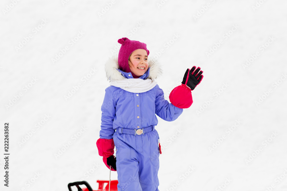 childhood, leisure and season concept happy little girl in snowsuit