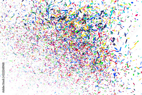 Festival. Multicolored explosion of particles of lead colored pencils on white background.