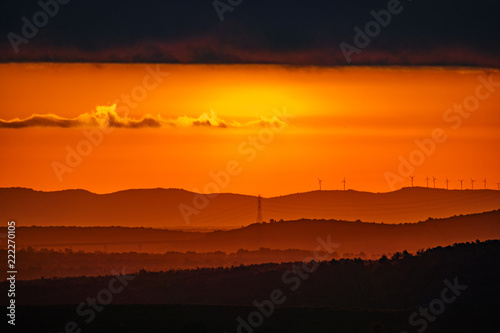 Blurred sunrise with orange colors and mountain layers