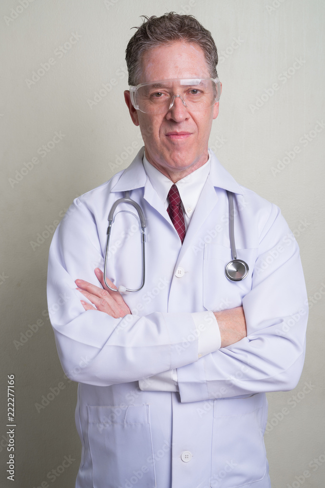 Portrait of mature man doctor against white background Portrait of mature man doctor against white background