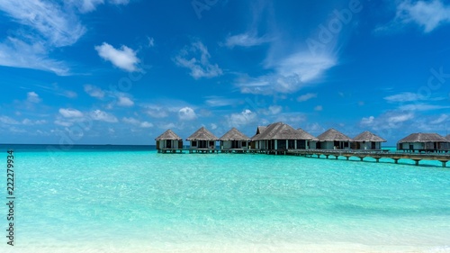 View of beautiful blue ocean water and bungalows in Maldives.