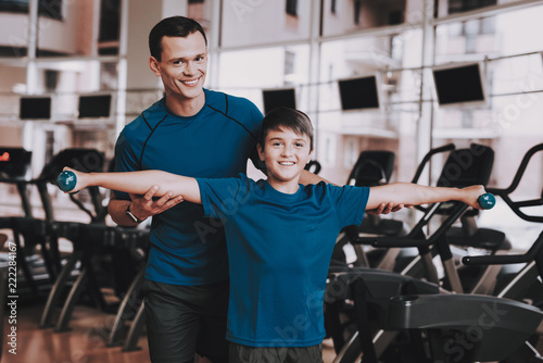 Young Father and Son Doing Exercises in Sport Club
