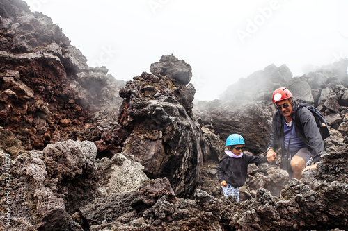 Padre e figlio in escursione sul vulcano Etna, Sicilia, Italy photo