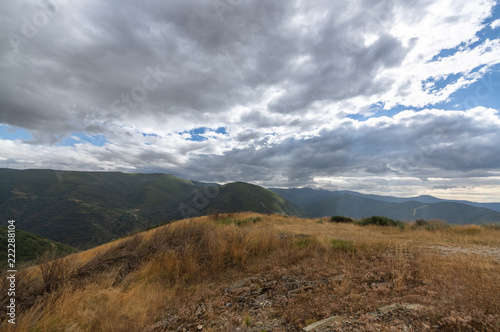 Dramatic sky with the sun rising through the clouds on the Way of Saint James (Camino de Santiago) in El Bierzo area between Foncebadon and Manjarin, in Leon, Spain.