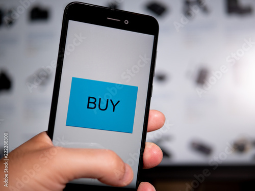 Shopping online in computer holding a phone. Buy icon. Looking for an item in screen