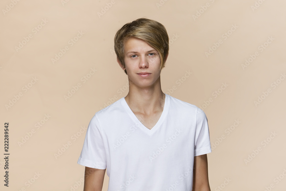Portrait of a handsome teenager smiling at the camera. Isolated on brown background Portrait of a handsome teenager smiling at the camera. Isolated on brown background