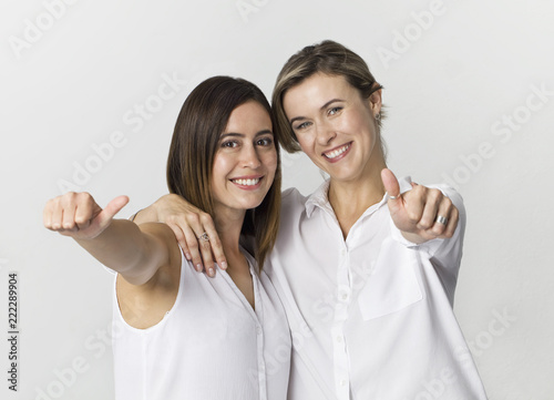 Beautiful attractive funny relaxed carefree girls with ok gesture in white shirt isolated on white background