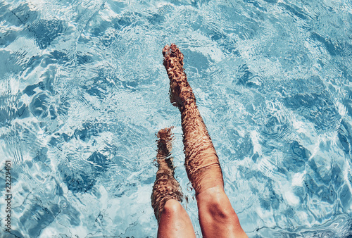 Low section of woman's legs in swimming pool photo