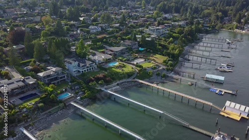 Ocean front mansions of rich people in drone aerial view. Beautiful homes with dock, pier along the sea. Private boats and pools on a little hill in Vancouver Pacific Coast Indian Arm. Dream houses photo
