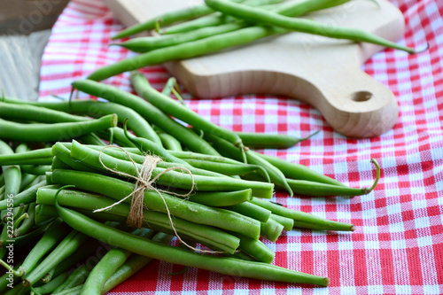 Healthy and benefits with bush beans.
Green beans tied with rope  on wooden background. photo