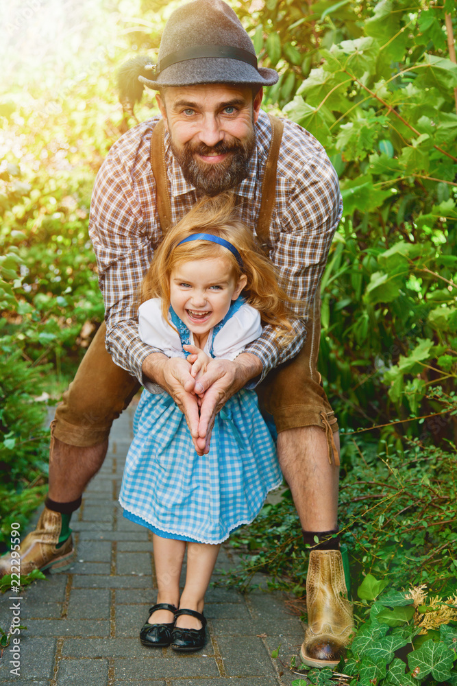 Man in traditional bavarian clothes Lederhose with little girl on his hands  in dirnndl. Papa and daughter having fun outdoor Stock-Foto | Adobe Stock