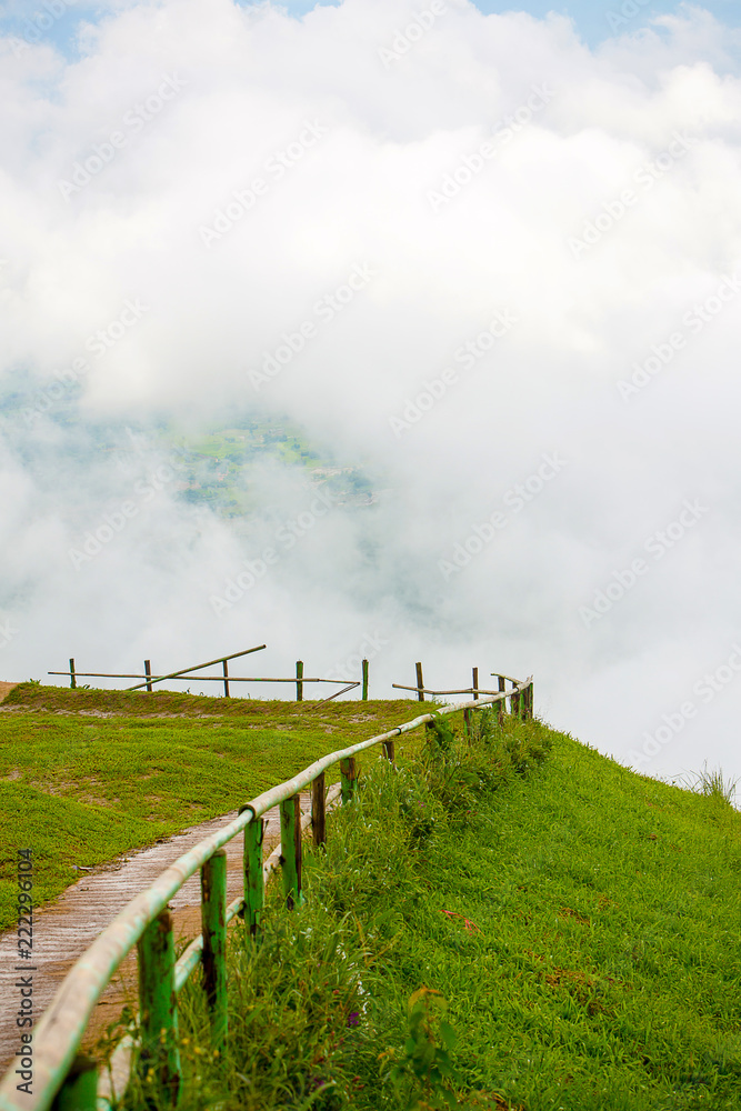 Wonderful walkway and wood barrier on the mountain peak with white cloudy background. the Beautiful way to view point. Image for background, wallpaper and copy space. Wonderful walkway and wood barrier on the mountain peak with white cloudy background. the Beautiful way to view point. Image for background, wallpaper and copy space.