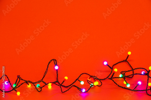 Christmas lights over red background. Colorful border with empty copy space for text.