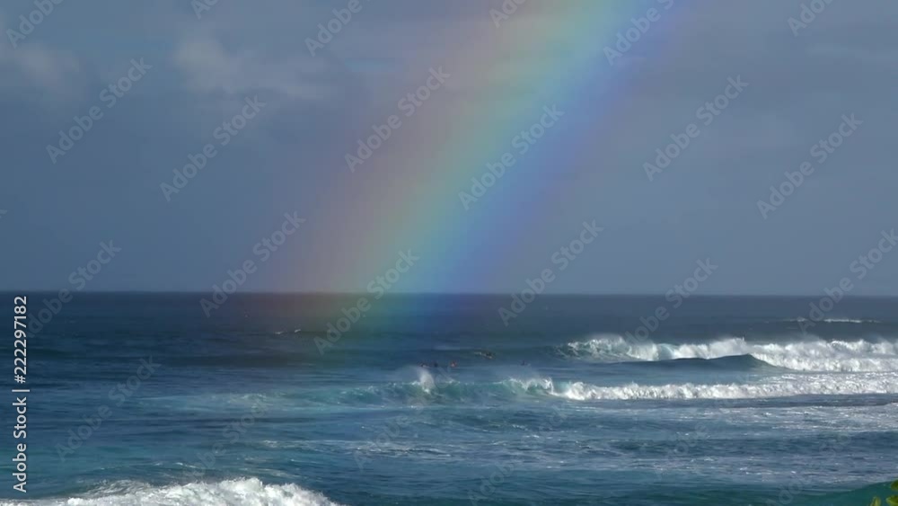 Big Rainbow over the ocean in slow motion. rolling waves in the distance