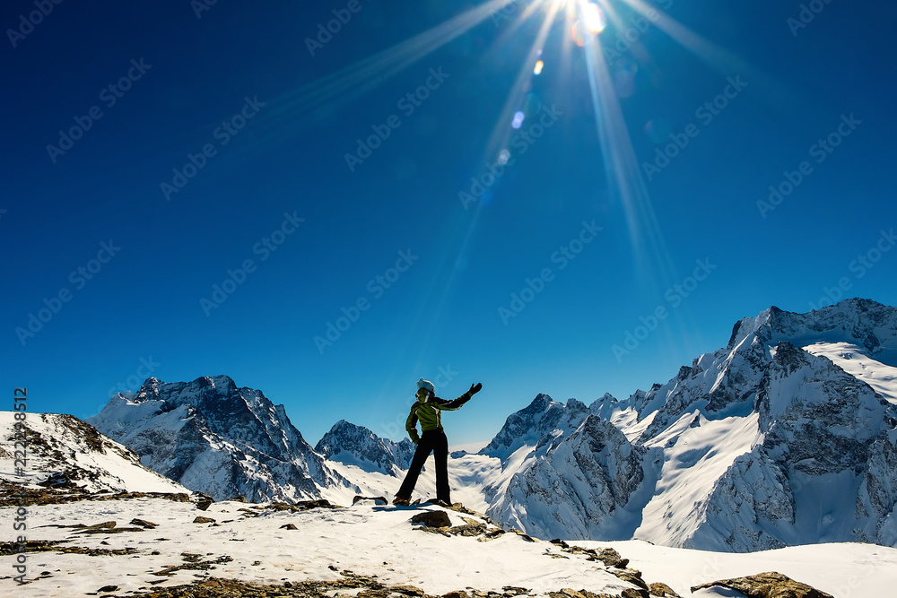 A girl at the top of the mountain looks at the snowy mountains A girl at the top of the mountain looks at the snowy mountains