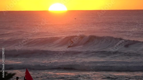 Surfers paradise at sunset. big and huge waves and colorful sun in background photo