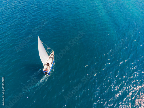 View from the top to a sports sailing yacht in the blue sea © Логофеди Дмитрий