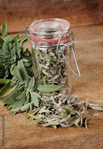 Fotografie glass with dried sage and fresh sage over wooden background