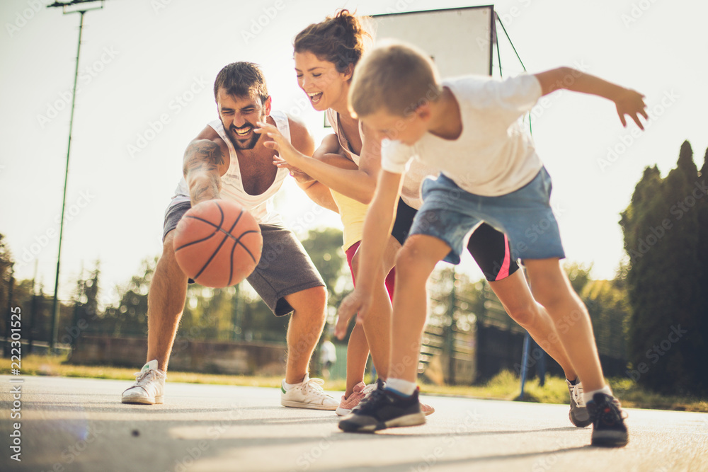 Family playing basketball outside.