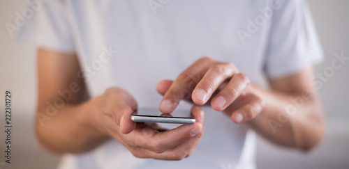 Panoramic of young caucasian man using apps on a touchscreen smartphone - Hands close-up focus on phone - Concept for using technology  shopping online  using mobile apps  texting  phone addiction