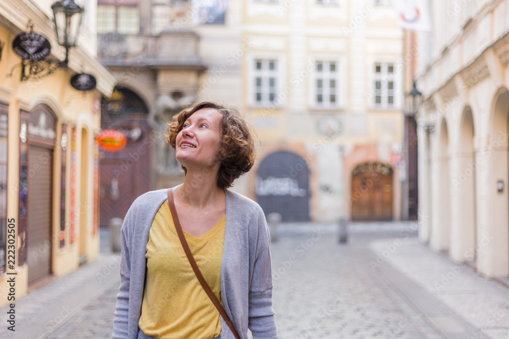 A tourist woman is walking around Prague on a sunny day.