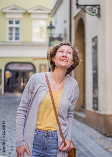 A tourist woman is walking around Prague on a sunny day. © vitaprague