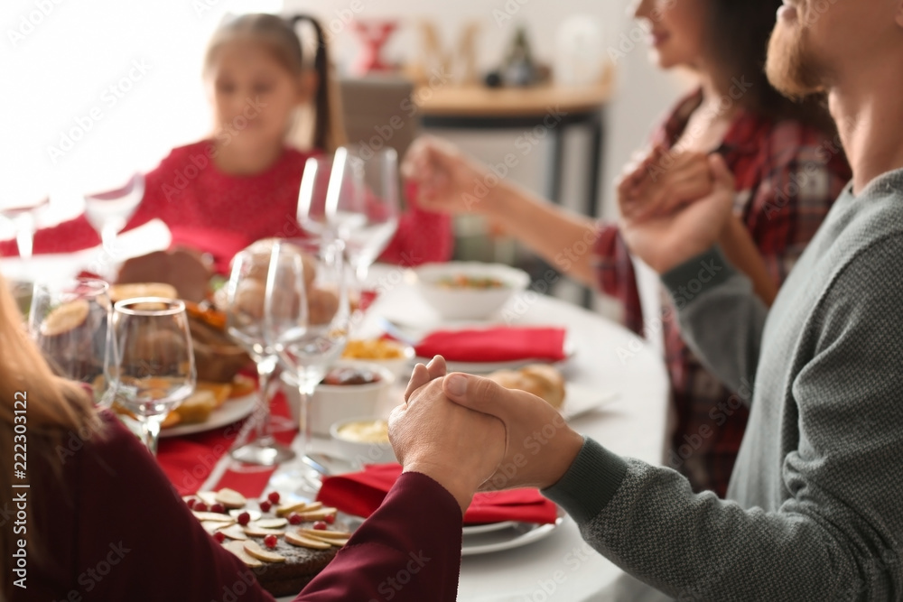 Family praying before having Christmas dinner at home Family praying before having Christmas dinner at home