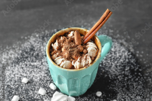 Cup of delicious cocoa with marshmallows on grey table