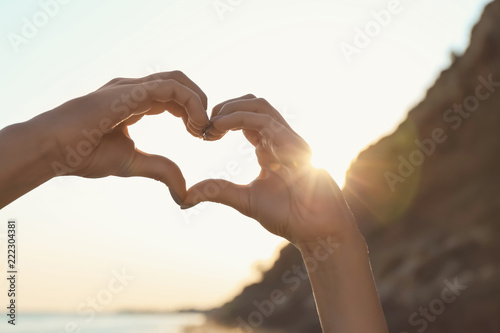 Woman making heart with her hands outdoors