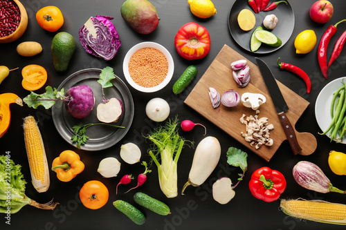 Different vegetables on black wooden background, flat lay