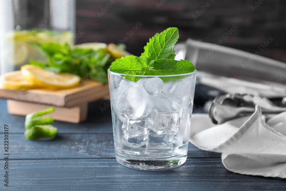 Glass with ice for mojito cocktail on wooden table Glass with ice for mojito cocktail on wooden table