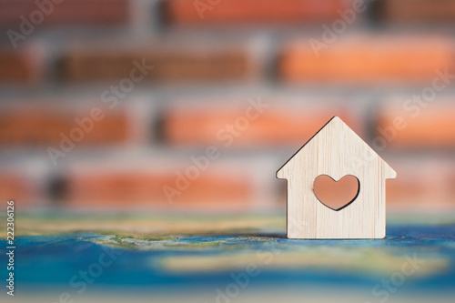 Wooden house on world map photo