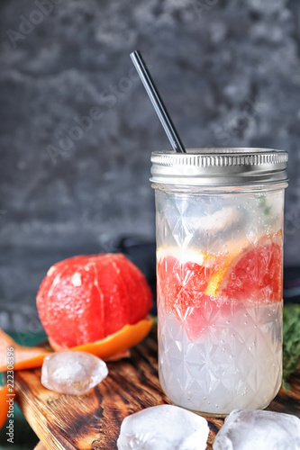 Jar with refreshing grapefruit lemonade on table