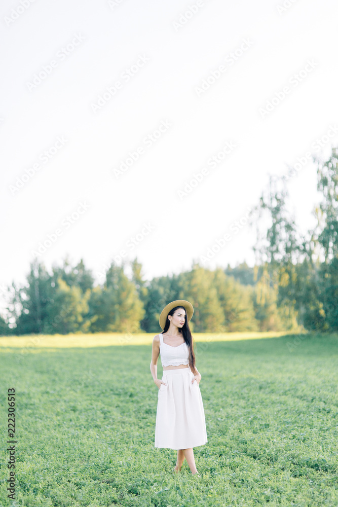 Girl walking on the field, in a hat and summer dress. Smiling and laughing, beautiful sunset in the forest and in nature. White dress and rye, sloping fields. Happy traveler, lifestyle. Girl walking on the field, in a hat and summer dress. Smiling and laughing, beautiful sunset in the forest and in nature. White dress and rye, sloping fields. Happy traveler, lifestyle.