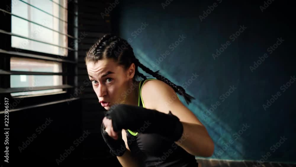 beautiful young moving boxing woman training punching in fitness studio. Fit female preparing to boxing competition. Wellness, fighting, motivation, martial arts, self defense concept beautiful young moving boxing woman training punching in fitness studio. Fit female preparing to boxing competition. Wellness, fighting, motivation, martial arts, self defense concept