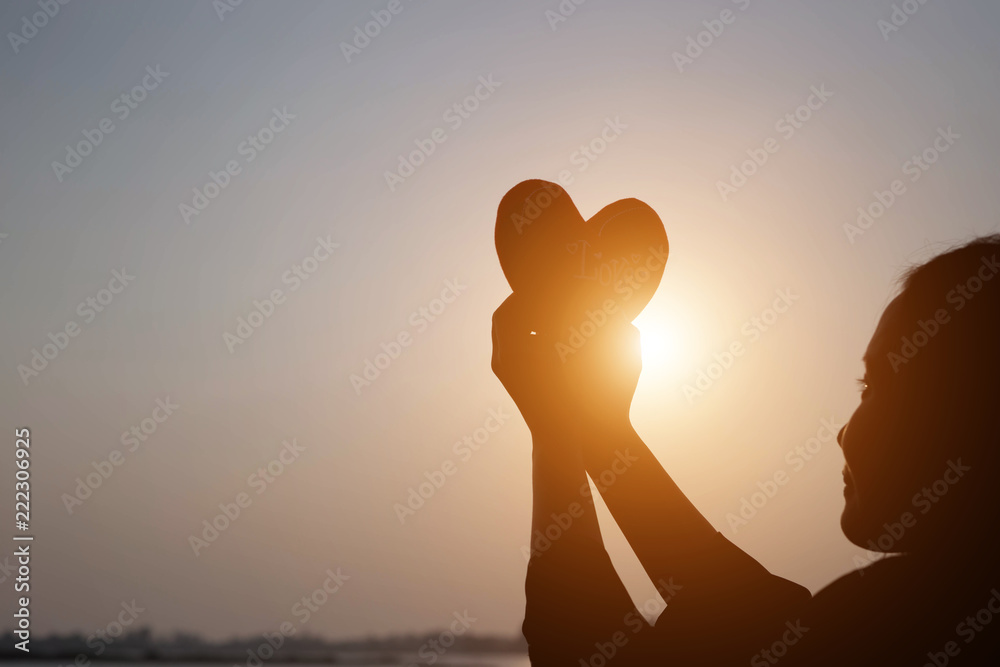 Happy woman on the sunset in nature in summer with open hands 