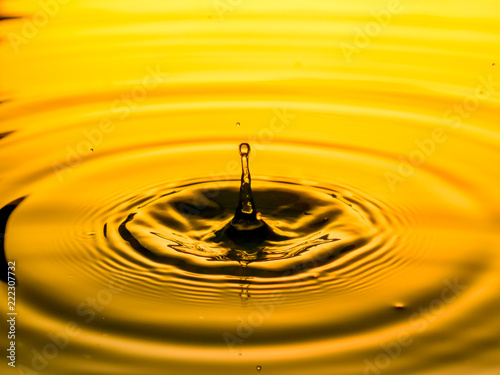 close up of a drop oil on a yellow background