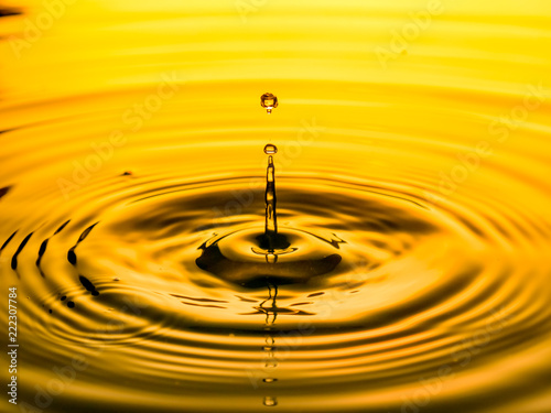 close up of a drop oil on a yellow background