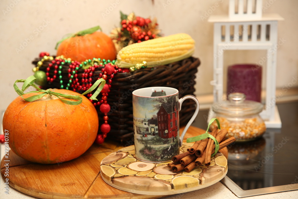 Fresh pumpkin and corn with decoration and coffee mag and candle in the kitchen. Autumn still life. Fresh pumpkin and corn with decoration and coffee mag and candle in the kitchen. Autumn still life.