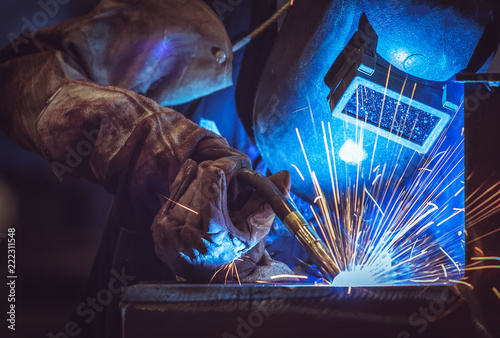 Industrial Worker at the factory welding steel structure